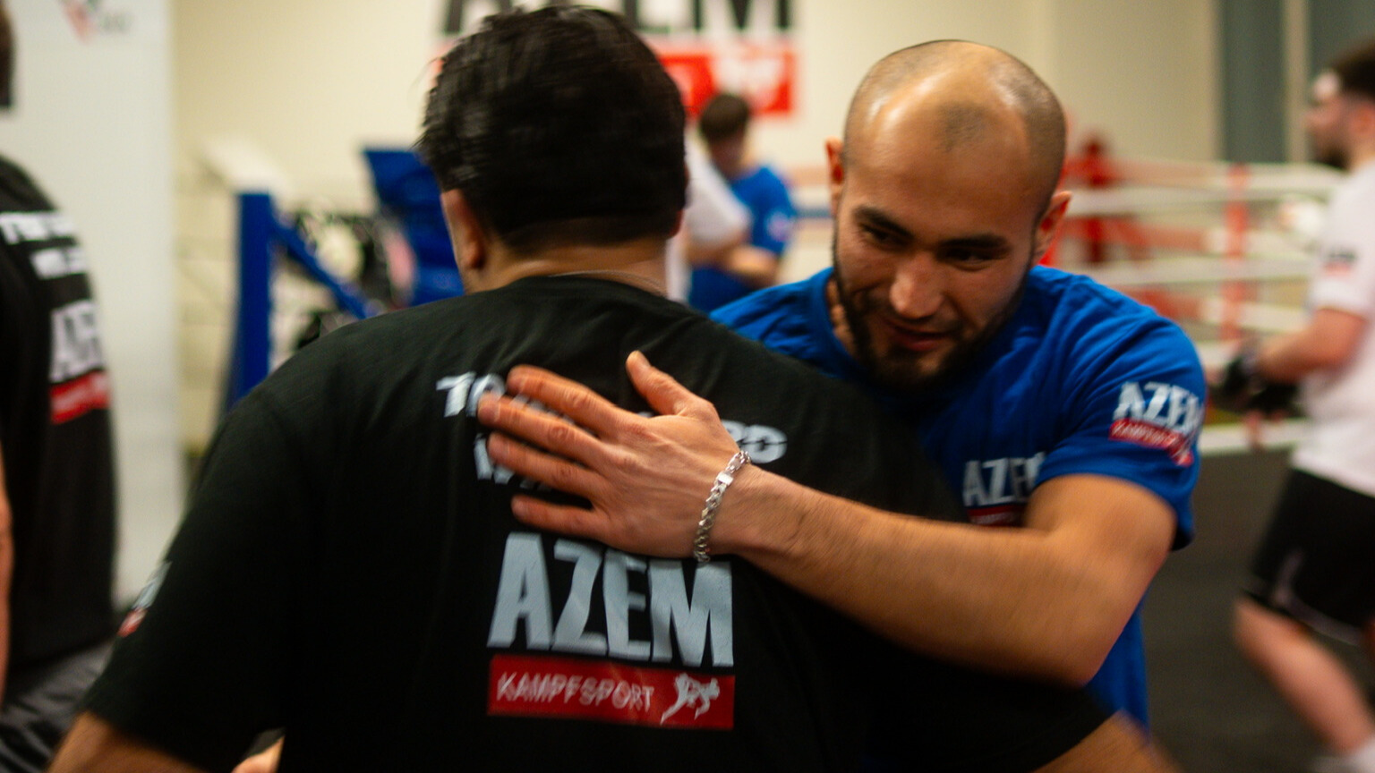 Sportler umarmen sich nach dem Training im AZEM Gym.