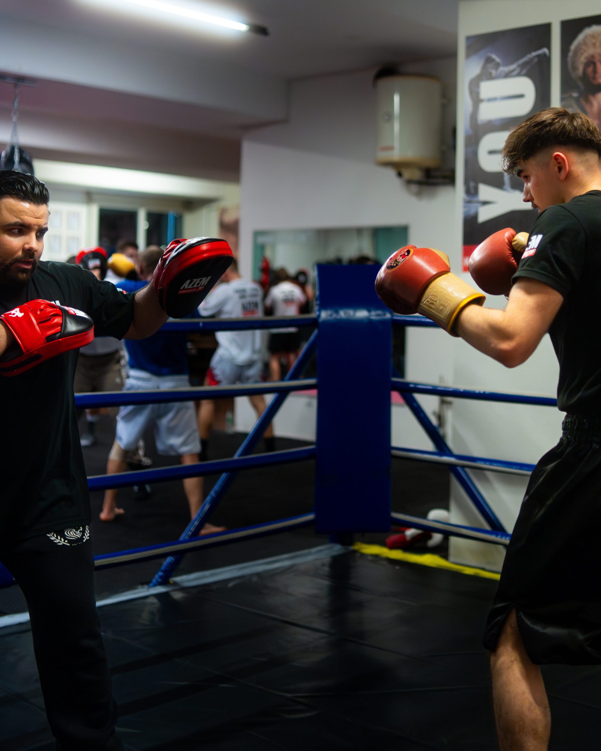 Trainer trainiert jungen Sportler mit roten Boxhandschuhen.
